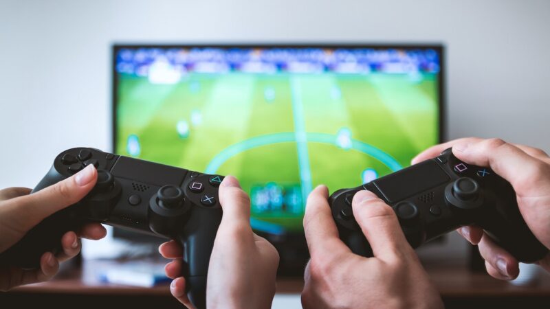 two people holding gaming console